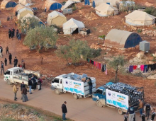 Trucks delivering aid to a refugee camp